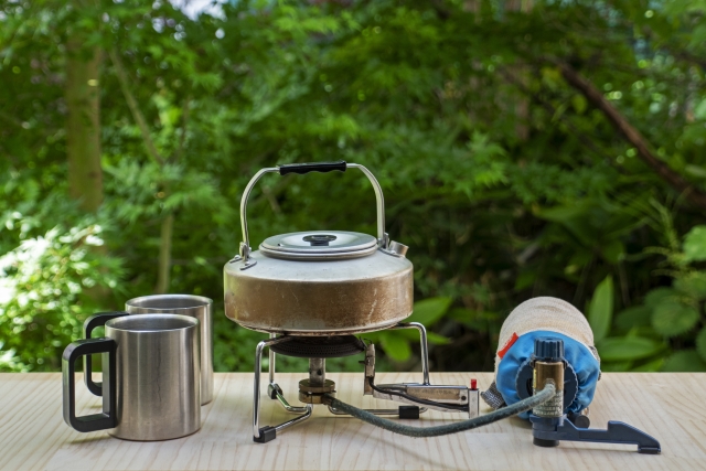 森の中でキャンプケトルとステンレスマグを並べた風景