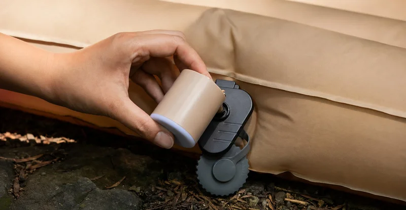 インフレーターマットのバルブに電動ポンプを差し込んでいる様子
