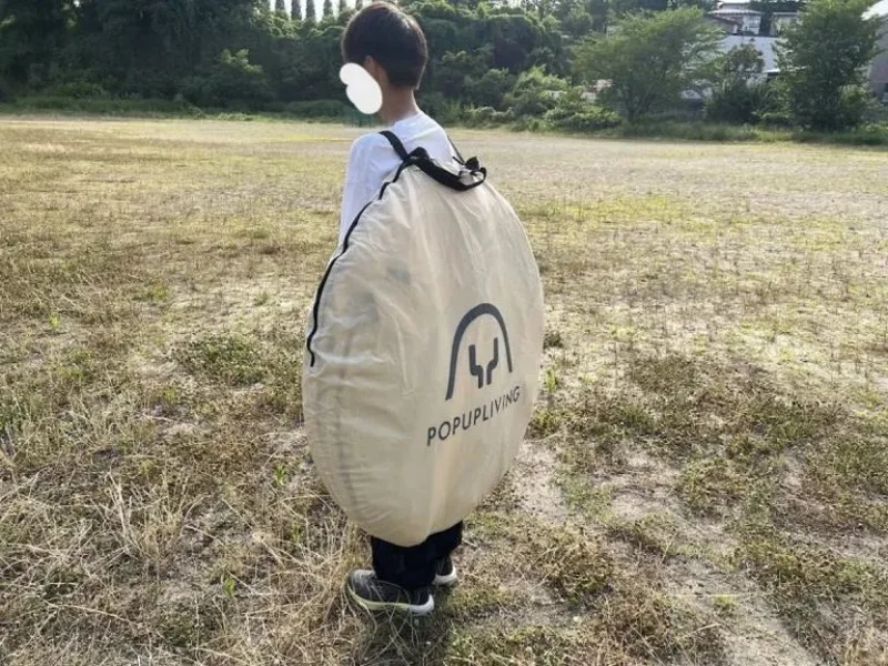 ポップアップリビングを背負って運ぶ様子