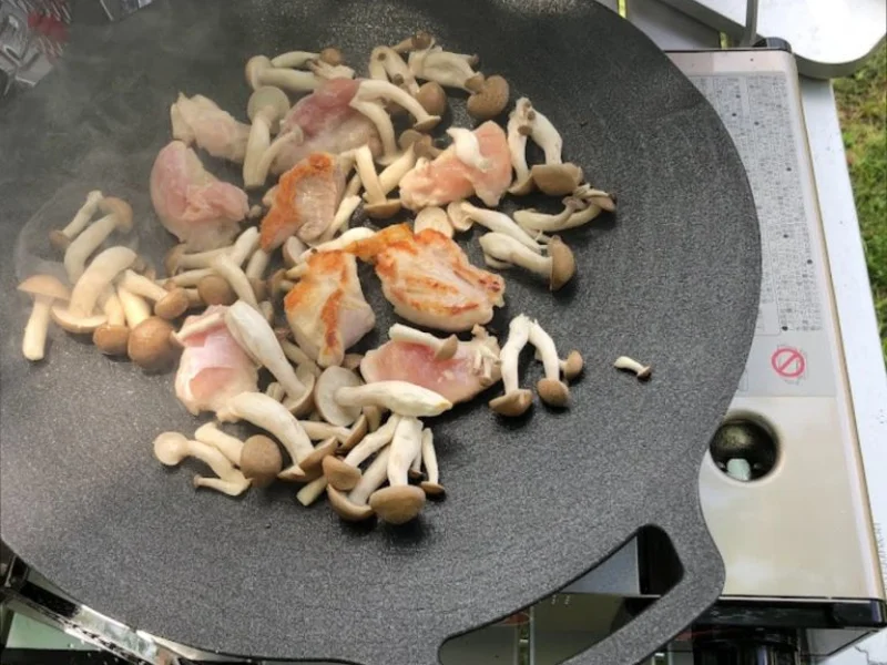 マルチグリドルで鶏肉ときのこを炒めているキャンプ料理の様子