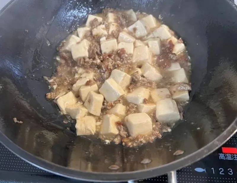 鉄フライパンで麻婆豆腐を調理している様子