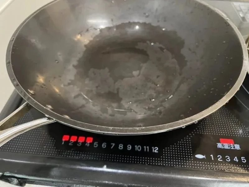 IHコンロの上で鉄フライパンを加熱して水分を飛ばしている様子