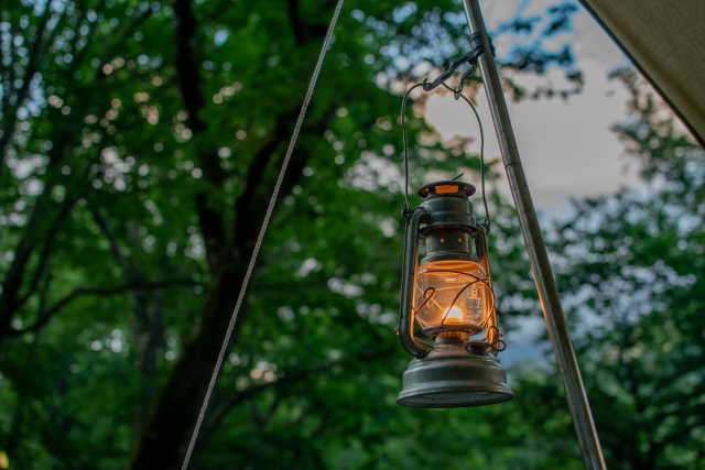 木々の中で吊るされたアンティークランタンの明かり
